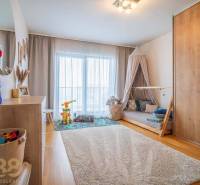 Children's room with toys, bed, and wardrobe, floor with wooden decor in a family house.
