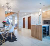 Interior of a family house with a dining table, staircase, and Christmas tree.