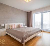Bedroom in a family house with a bed, nightstands, and a floor with a wood decor.