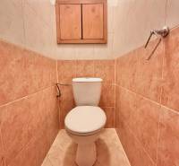 A bathroom with tiles and a wooden cabinet in a 3-room apartment.