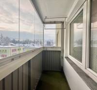 A glazed balcony with a view of the snowy panorama of the town of Turzovka on Centrum Street.