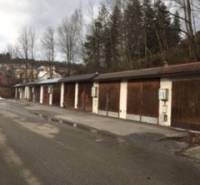 Row of garages on Centrum Street in Turzovka with the designation of a verified member of the real estate agency.