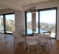 Dining room in a 4-room apartment with a glass wall and a floor with a wood decor.