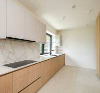 A kitchen in a 4-room apartment with white cabinets, a marble surface, and wooden decor.