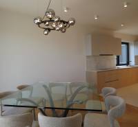 Dining room with a glass table and chairs, 4-room apartment, floor with wood decor.