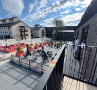 Square exterior at Sýpka in Bratislava - Jarovce with a terrace and brick buildings.