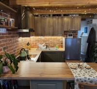 A kitchen with brick tiles, a wooden cabinet, and string lights in warehouses and halls.