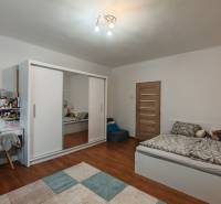 Children's room with a bed, wardrobe, desk, and wooden decor flooring in a family house.