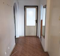 A hallway with arches and a wooden decor floor in a 2-room apartment.