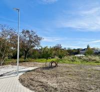 A residential plot in Malinovo on Malinovo Street with a concrete sidewalk and trees.