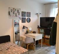 A room with a bed, a desk, and decorations in a 3-room apartment, floor with wooden decor.