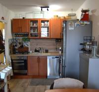 A kitchen in a 3-room apartment with a wooden decor floor and appliances.