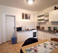 A kitchen in a family house with white furniture, a stove, and a dining table.