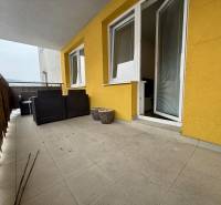 A balcony of a 2-room apartment in Žilina with a tiled floor and garden furniture.