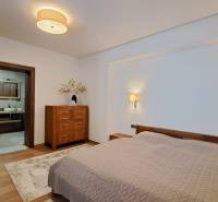 A bedroom in a two-room apartment with a bed, wooden furniture, and a floor with a wooden decor.