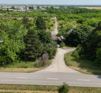 A path bordered by greenery offers a view of commercial land in Ivanka pri Nitre.