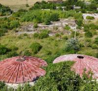 Commercial plots in Ivanka pri Nitre with circular roofs, surrounded by lush greenery.