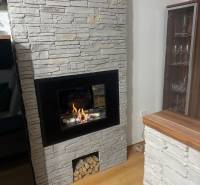 Fireplace with stone cladding, spacious room, floor with wooden decor, 3-room apartment.