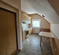 A kitchen in a building with a wood-patterned floor and basic equipment.