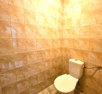 A restroom in a building with ceramic tiles and a floor with a marble design.
