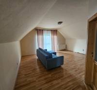 Interior with wood-patterned flooring, a sofa, and curtains in a building.