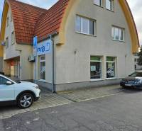 The building on Children's Square in Galanta with an arched roof and parking spaces.
