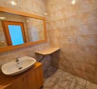 Bathroom with ceramic tiles, a sink, and a mirror in the building.