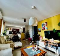 Living room with a yellow wall and wood-patterned flooring in a 4-room apartment.