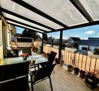 A terrace with seating and flower pots in a 4-room apartment, suitable for relaxation.