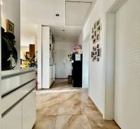 A hallway with light tiles, white walls, and decorative photographs in a 4-room apartment.