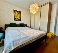 Bedroom in a 4-room apartment with a double bed, wardrobe, and wooden decor flooring.