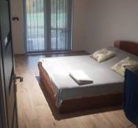 A bedroom in a family house with a bed and a floor with a wooden decor.
