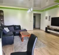 Living room in a family house with a leather sofa, television, and wooden decor flooring.