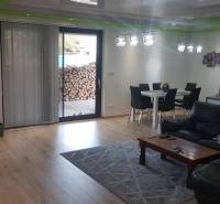 Living room in a family house with a wooden decor floor, sofa, and dining table.