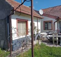 A family house in Nové Zámky with garden furniture, a satellite dish, and a grassy yard.