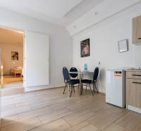 1-bedroom apartment with wood-patterned flooring, a kitchen unit, and a dining table.