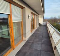 The balcony of a family house on Veterná in Krakovany with glass railings and French windows.