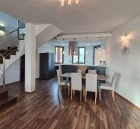 Interior of a family house with a kitchen, dining room, and staircase on a floor with a wooden decor.