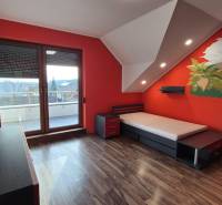 Children's room with a wall featuring a dinosaur motif and a floor with a wooden decor in a family house.