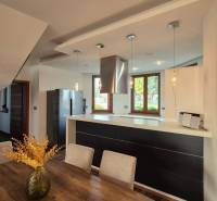 A kitchen with a dining table and a wooden decor floor in a family house.