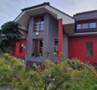 A family house on Veterná Street in Krakovany, surrounded by trees and a landscaped garden.