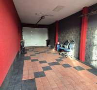 A garage in a family house with tiles and red walls, with office chairs.