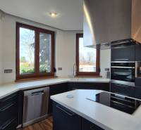 A kitchen in a family house with a white countertop, black cabinets, and appliances.