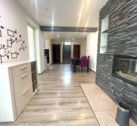 Interior of a family house with a fireplace, wood-patterned flooring, and wall decoration.