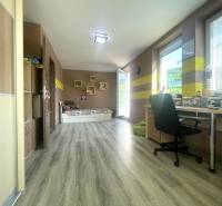 A spacious room in a family house with a wooden decor floor and a work desk.