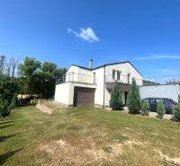 A family house in Melčice-Lieskové with a spacious garden and terrace, and a car on the driveway.