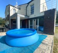 A family house in Melčice-Lieskové with a swimming pool and a terrace with rattan furniture.