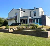 A family house in Melčice-Lieskové with a garden and terrace; grassy area with flowers.