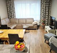 Living room in a 3-room apartment with a leather sofa and a wooden decor floor.
