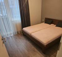 Bedroom in a 3-room apartment with wood-patterned flooring and a double bed.